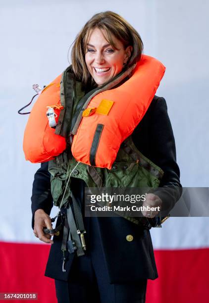 Catherine, Princess Of Wales packs a life vest before setting it off during her visit to Royal Naval Air Station Yeovilton on September 18, 2023 in...