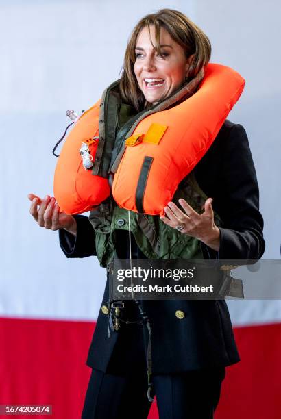 Catherine, Princess Of Wales packs a life vest before setting it off during her visit to Royal Naval Air Station Yeovilton on September 18, 2023 in...