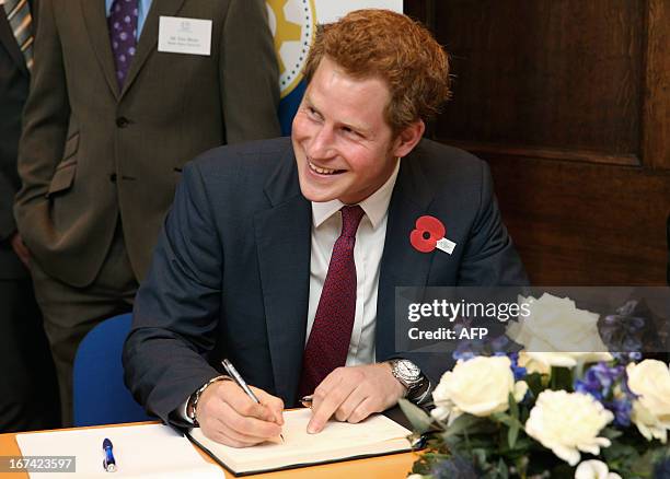 Britain's Prince Harry signs the visitors book during a visit to the Headway brain injury association as he officialy opens the Bradbury House, the...