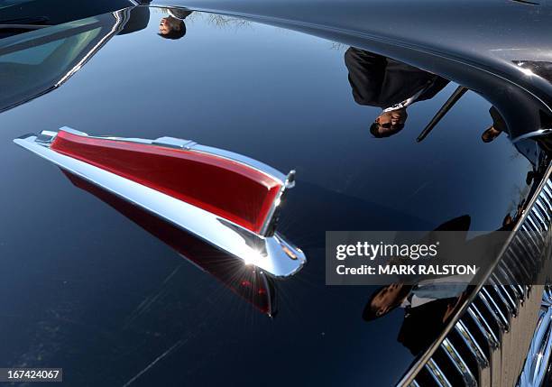 Chinese security is reflected on the Chinese-made Hongqi limousine used by the French President after his arrival in Beijing on April 25, 2013....