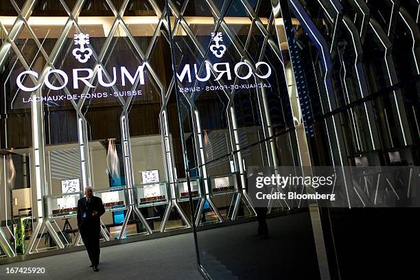 Visitor passes the Montres Corum booth at the Baselworld watch fair in Basel, Switzerland, on Thursday, April 25, 2013. The annual fair attracts...