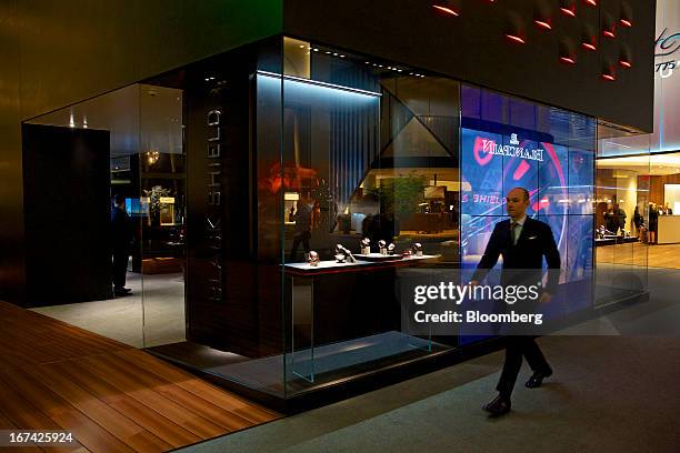 Visitor passes a display of wristwatches at the Tudor booth during the Baselworld watch fair in Basel, Switzerland, on Thursday, April 25, 2013. The...