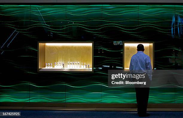 Visitor looks at a display of wristwatches displayed at the Rolex Group booth during the Baselworld watch fair in Basel, Switzerland, on Thursday,...