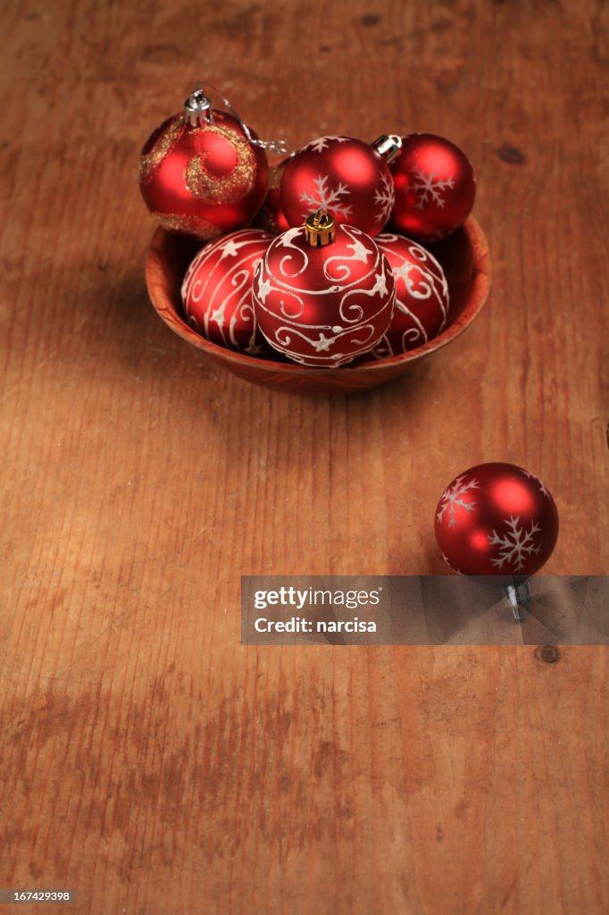 Baubles in a bowl on wooden background