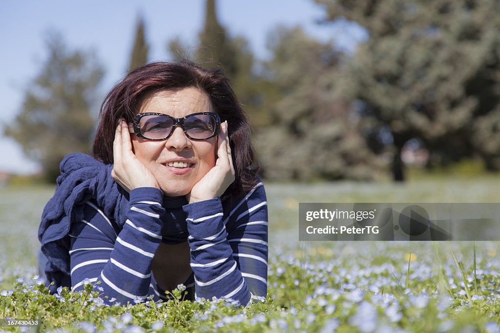 Mid aged woman relaxing on grass