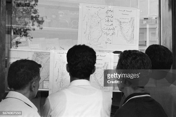 Syrians look, on October 24, 1973 in the streets of Damascus, at the maps which give the positions of the belligerent countries at the time of the...