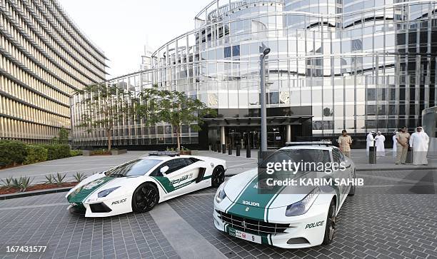 Picture taken on April 25, 2013 shows Lamborghini and Ferrari police vehicles at the foot of the Burj Khalifa tower in the Gulf emirate of Dubai. Two...