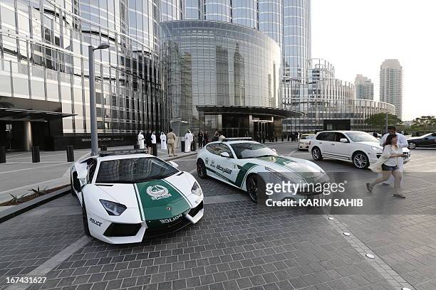 Picture taken on April 25, 2013 shows Lamborghini and Ferrari police vehicles at the foot of the Burj Khalifa tower in the Gulf emirate of Dubai. Two...