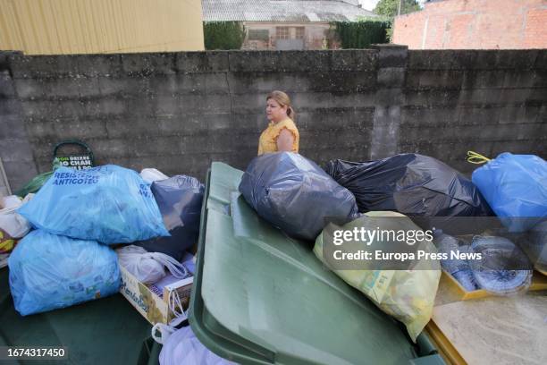 Woman walks past overflowing garbage containers during the fourth week of the strike in Vilalba garbage collection, on September 11 in Vilalba, Lugo,...