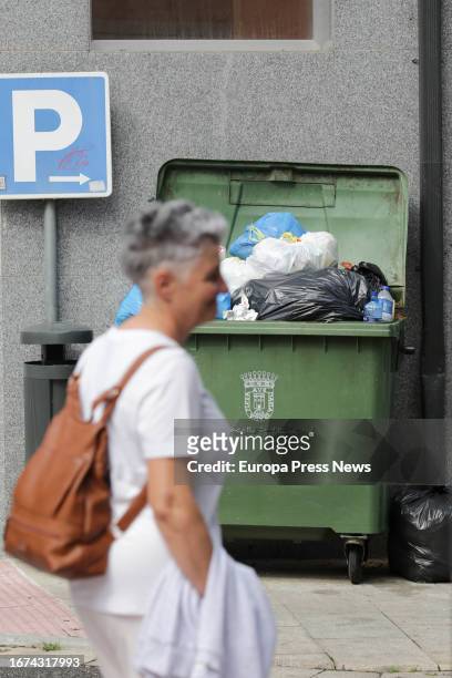 Woman walks next to an overflowing garbage container during the fourth week of the strike in Vilalba garbage collection on September 11 in Vilalba,...