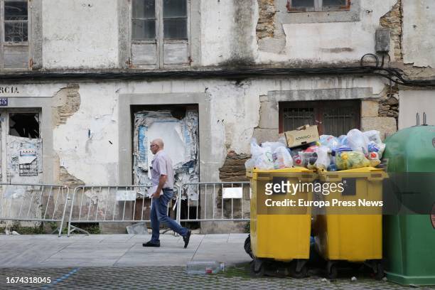 Man walks next to an overflowing garbage container during the fourth week of the strike in Vilalba garbage collection on September 11 in Vilalba,...