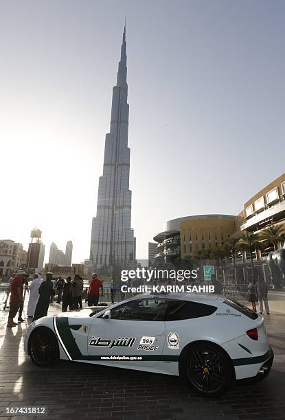 Picture taken on April 25, 2013 shows a Ferrari police vehicle in front of the Burj Khalifa tower in the Gulf emirate of Dubai. Two weeks after...