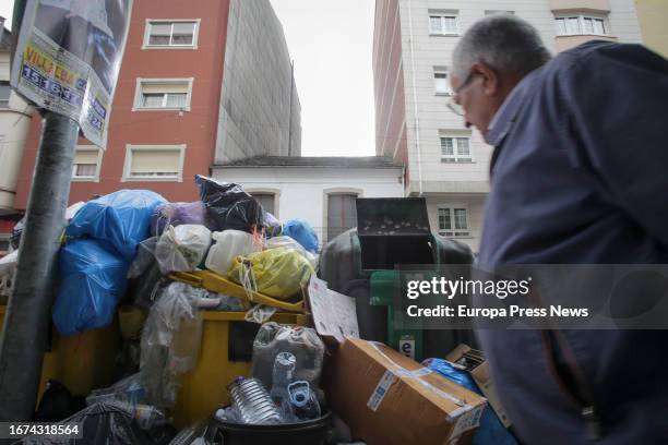 Man walks next to an overflowing garbage container during the fourth week of the strike in Vilalba garbage collection on September 11 in Vilalba,...