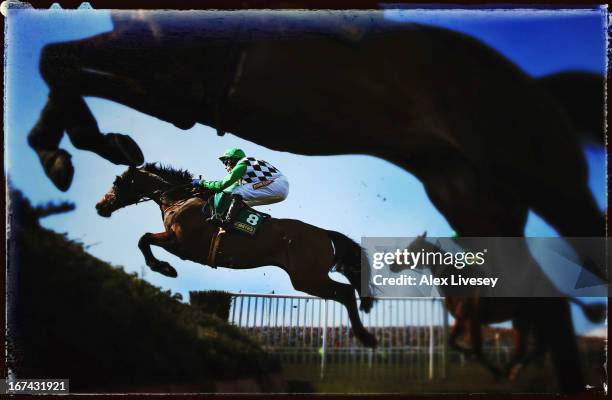 Problema Tic ridden by Tom Scudamore jumps a fence during The John Smith's Handicap Steeple Chase at Aintree Racecourse on April 6, 2013 in...