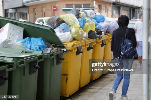 Woman walks past overflowing garbage containers during the fourth week of the strike in Vilalba garbage collection, on September 11 in Vilalba, Lugo,...