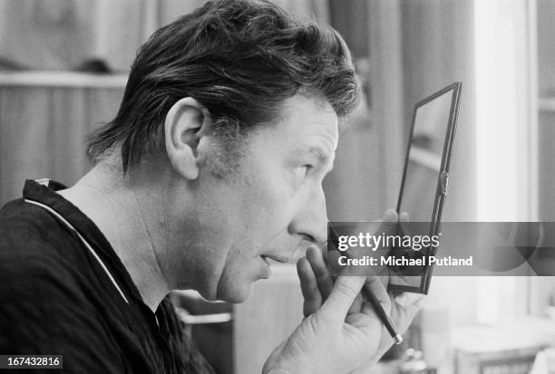 English comedian, singer, actor and variety performer Max Bygraves putting on make-up in a dressing room, 22nd January 1973.