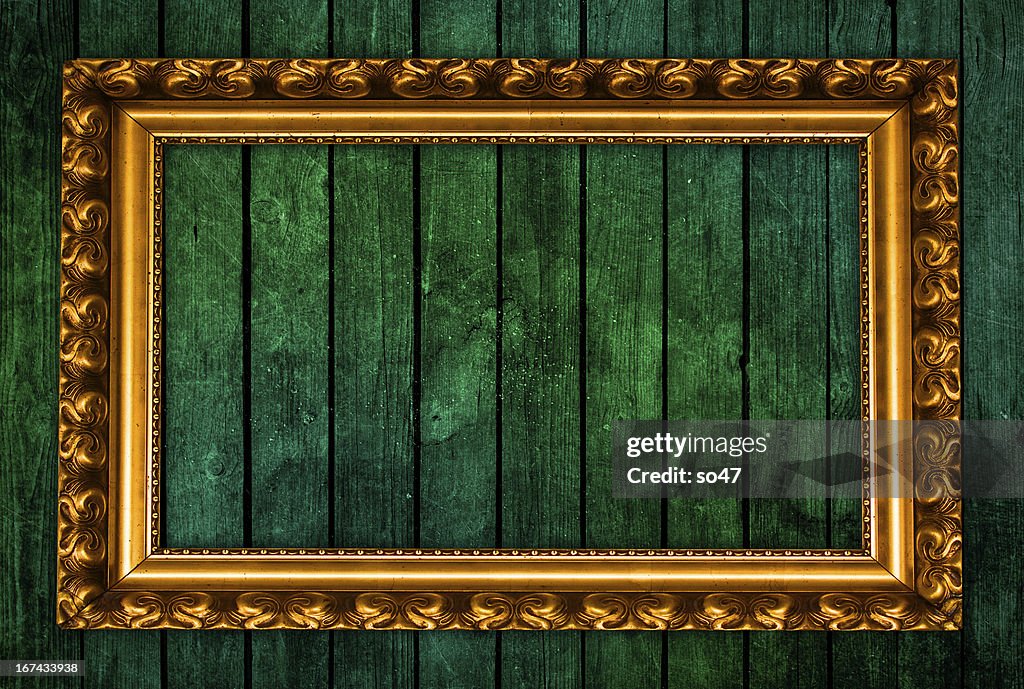 Golden picture frame on green background