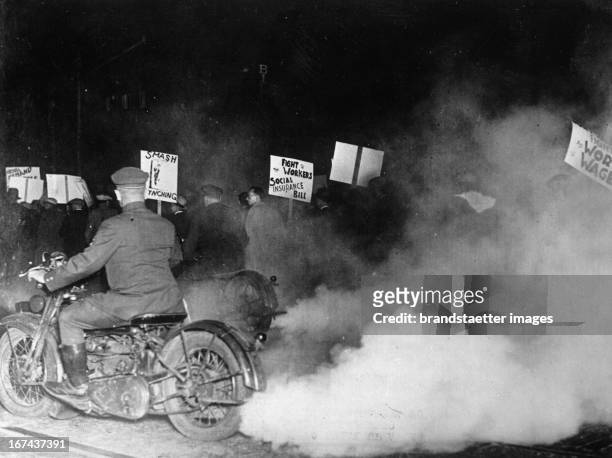 New York police on motorcycles wrap a demonstration of communists in fog to prevent the demonstrators at the march-past in front of a building in...