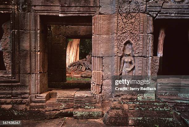 View of an interior courtyard with an Apsara with a missing head, chipped away by looters in the Preah Khan temple in the ancient Angkor temple...