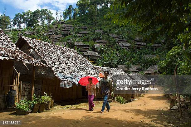 Young couple walks through Mae La Oon Refugee Camp, home to approximately 14,000. The camp is pitched on the sides of a very steep valley, and there...