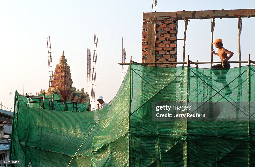 A day laborer works on a wall on a re-furbished guesthouse...