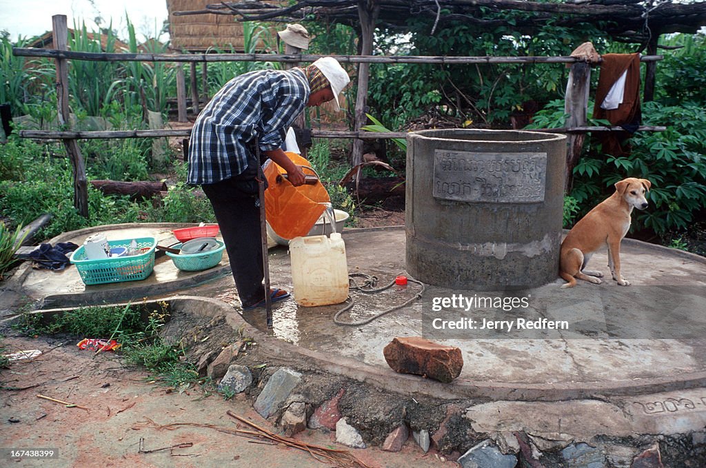 Bun Na gathers water from a communal well during his first...