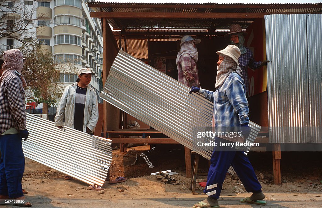 Construction workers build themselves temporary houses from...