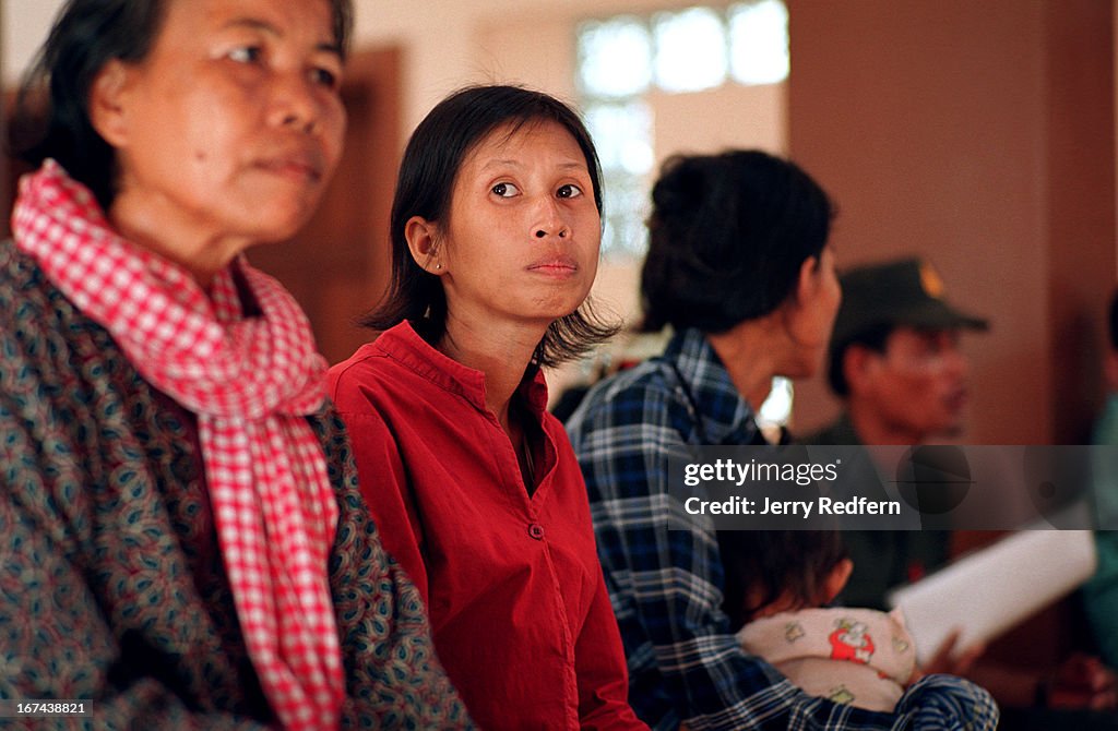 Heng Phala, 24, waits among other patients at an HIV clinic...