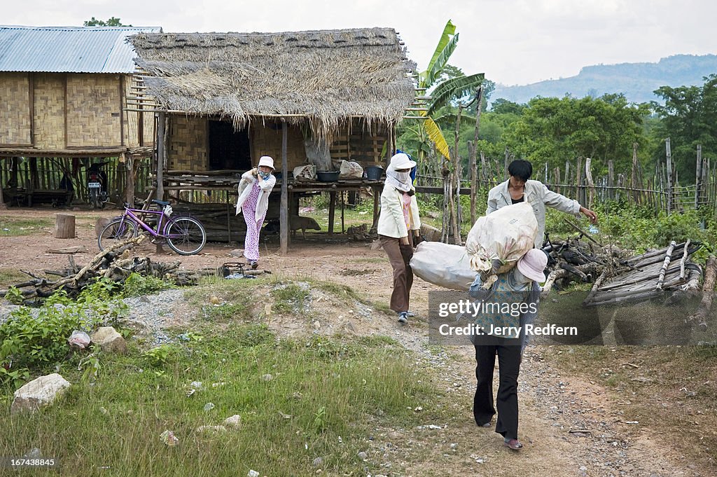 Vietnamese women haul sacks of scrap metal to a waiting...