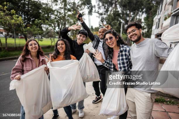retrato de um grupo de jovens voluntários, limpando o bairro da cidade - happy earth day - fotografias e filmes do acervo