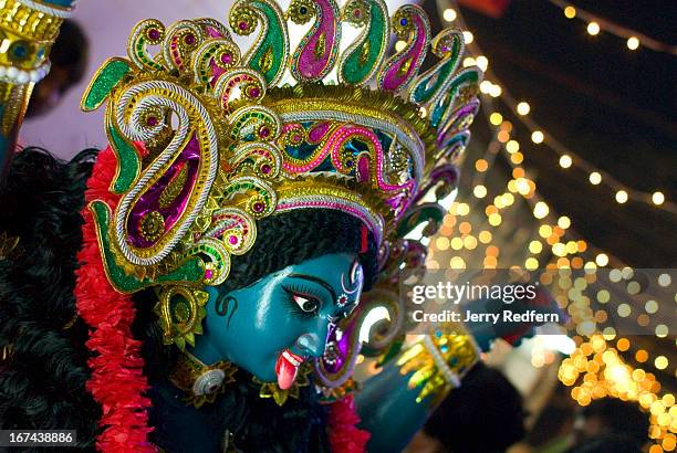 Men unload a statue of the Hindu goddess Kali from a truck to place in a neighborhood shrine for the Kali Puja religious festival. In Kolkata, Kali...