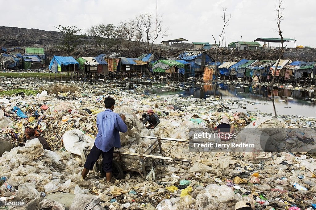 A man rinses recycled plastic bags in a sewage and garbage-...