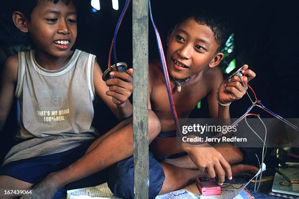 Two boys listen to a one-speaker radio they improved with an extra speaker in their room at the Cambodian Light Children Association. Pat Noun...