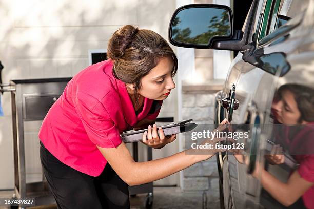 automobile insurance adjuster inspecting damage to vehicle - auto tablet stockfoto's en -beelden