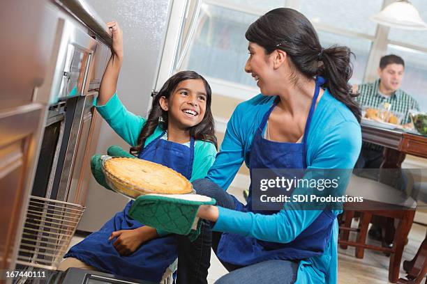 happy mom and daughter baking together in modern kitchen - sweetie pie stock pictures, royalty-free photos & images