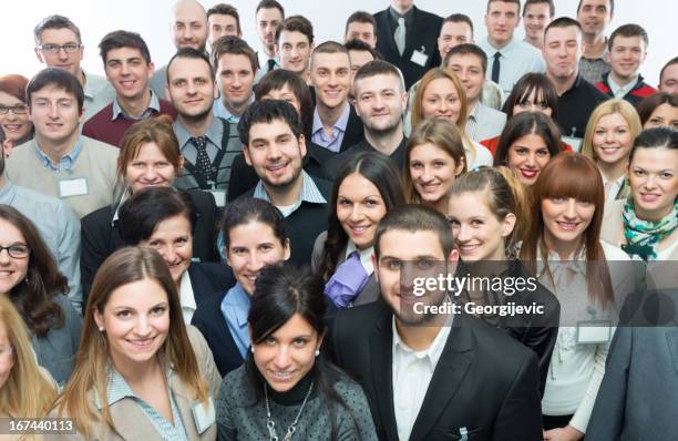 large group of people smiling in camera - large business meeting stock pictures, royalty-free photos & images