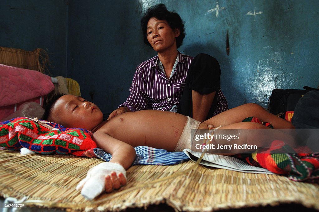 Chang Y Sieng tends to her 5-year-old grandson in the...