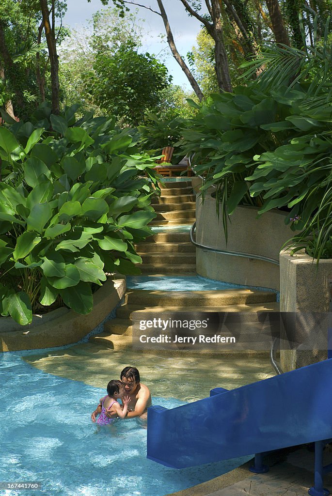 A father plays with his daughter in the children's pool at...