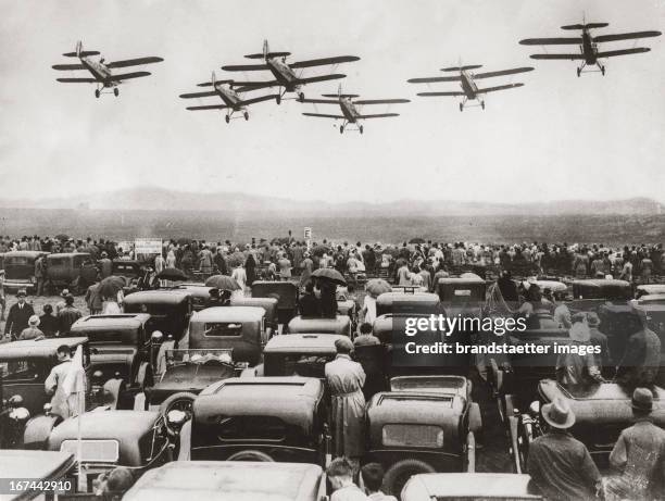 Aeroplane in formation over parking cars during a competition of the Royal Air Force in Hendon/England. About 1935. Photograph. Flugzeuge im...