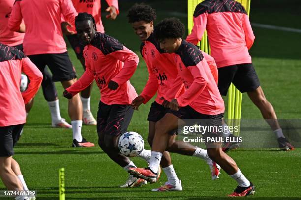 Manchester City's Belgian midfielder Jeremy Doku , Manchester City's Norwegian midfielder Oscar Bobb and Manchester City's English defender Rico...