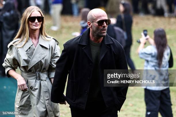 British actor Jason Statham and his partner British actress and model Rosie Huntington-Whiteley arrive to attend the catwalk presentation for British...