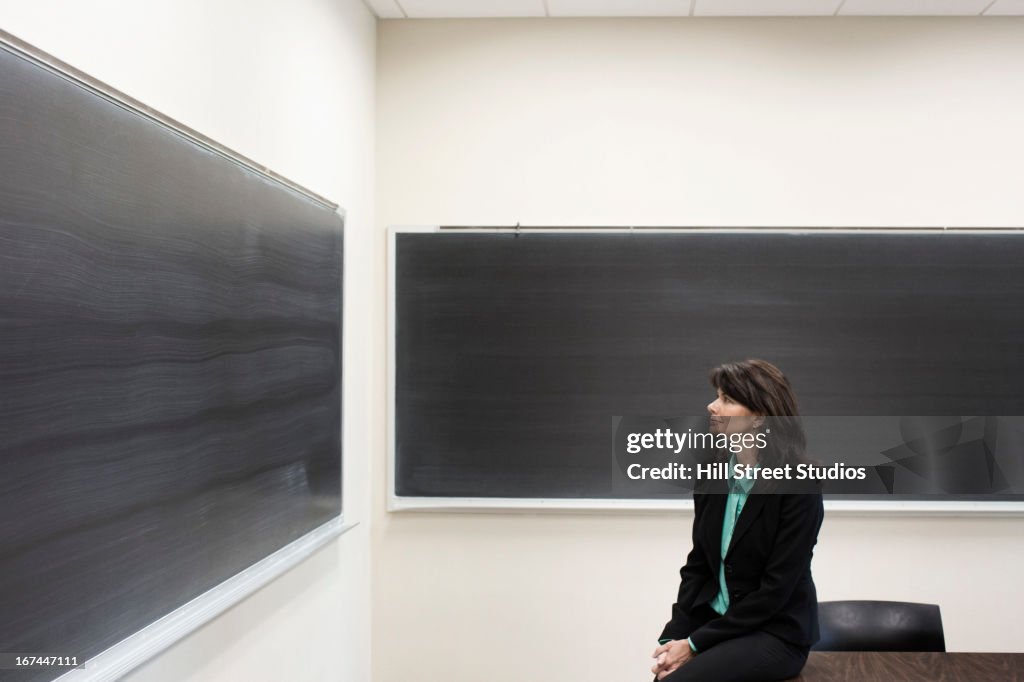 Caucasian teacher sitting in empty classroom