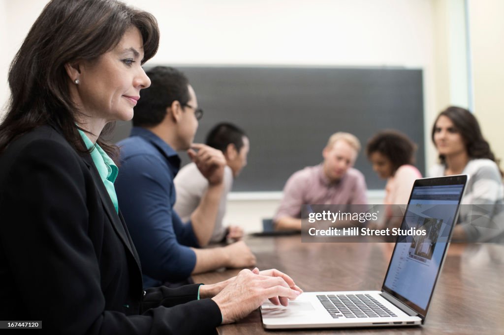 Teacher using laptop in classroom