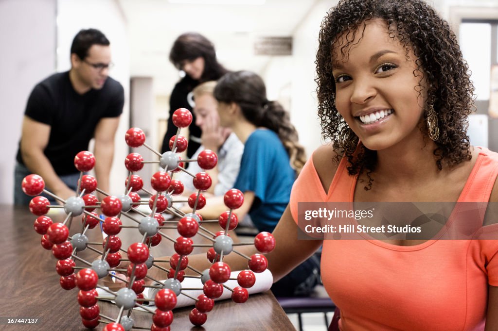 Student with molecular model in classroom