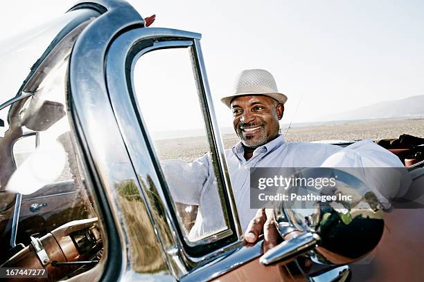 black man driving convertible - take a vintage summer road trip stock pictures, royalty-free photos & images