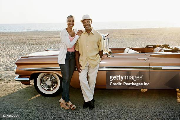 black couple standing by convertible - voiture de collection photos et images de collection