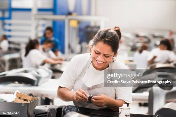 worker smiling in manufacturing plant - arbeider stockfoto's en -beelden