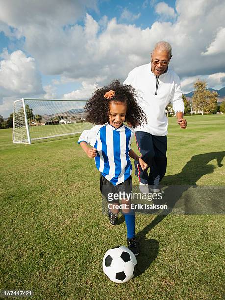 man playing soccer with granddaughter - old american football fotografías e imágenes de stock