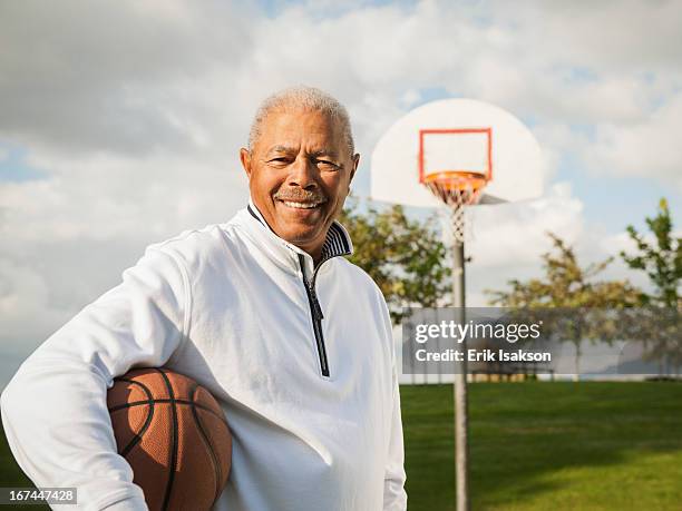 black man carrying basketball - old basketball hoop stock pictures, royalty-free photos & images