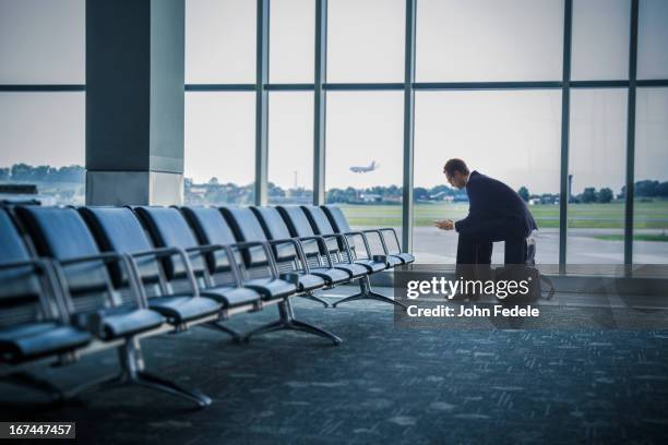 caucasian businessman sitting suitcase in airport - businessman distance window ストックフォトと画像